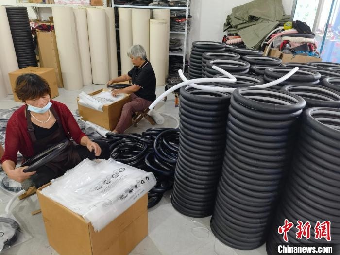 圖為村民在汽車飾品企業(yè)生產(chǎn)車間中工作。　呂子豪 攝