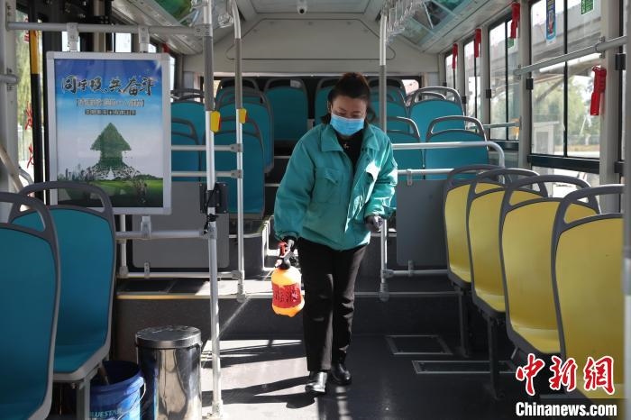 工作人員正在對(duì)公交車進(jìn)行消殺?！∮诰?攝
