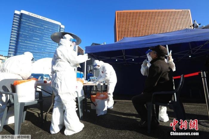 資料圖：韓國首爾，醫(yī)務(wù)人員對市民進(jìn)行新冠病毒檢測。