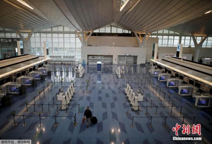 資料圖：日本東京，東京國際機(jī)場，一名乘客在國際航班航站樓的登機(jī)區(qū)。