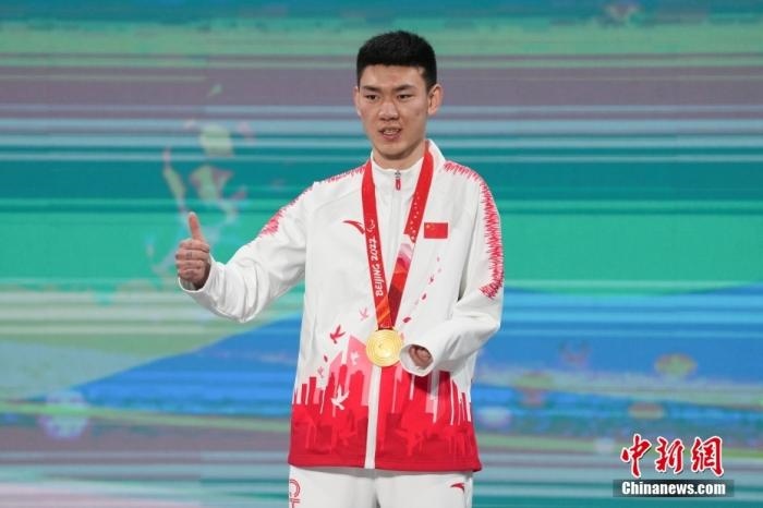 3月6日，梁景怡在延慶頒獎(jiǎng)廣場(chǎng)領(lǐng)獎(jiǎng)臺(tái)上豎起大拇指。當(dāng)日，在國(guó)家高山滑雪中心舉行的北京2022年冬殘奧會(huì)殘奧高山滑雪男子超級(jí)大回轉(zhuǎn)—站姿決賽中，中國(guó)選手梁景怡奪得冠軍。 <a target='_blank' href='/'>中新社</a>記者 楊華峰 攝