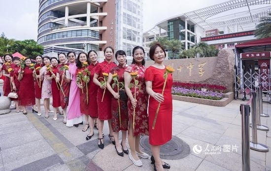 6月7日一早，廈門雙十中學(xué)考生家長(zhǎng)們身穿旗袍，手拿向日葵在考場(chǎng)外為孩子加油打氣，寓意“旗開得勝，一舉奪魁”。人民網(wǎng)記者 陳博攝