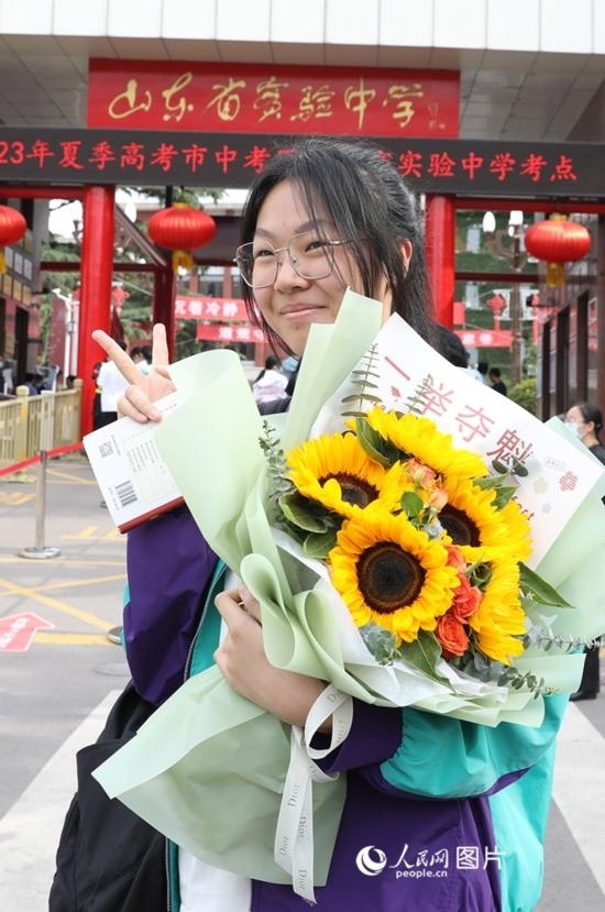 6月7日高考首日，山東67萬考生走進(jìn)考場(chǎng)，拼搏逐夢(mèng)。在山東省實(shí)驗(yàn)中學(xué)考點(diǎn)，考生進(jìn)考場(chǎng)前手捧向日葵花拍照留念，寓意“一舉奪魁”。人民網(wǎng)記者 劉祺攝