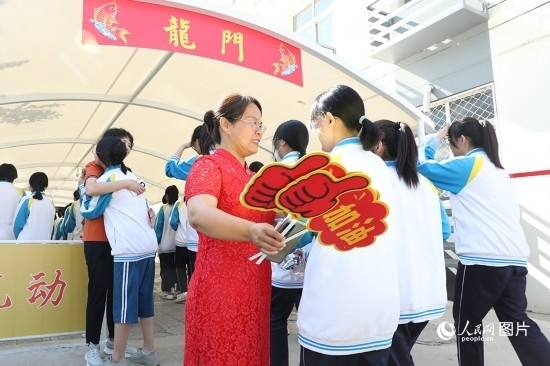 6月7日一早，雄安新區(qū)安新中學(xué)老師在給同學(xué)們加油鼓勁兒。人民網(wǎng) 李兆民攝