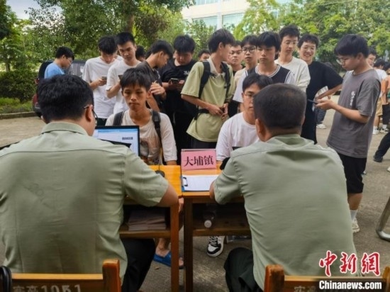 專武干部在發(fā)放兵役登記證。韋碩 攝