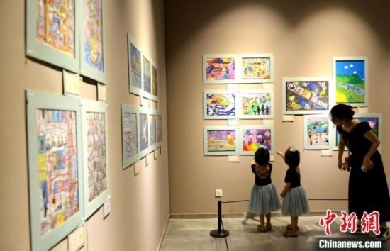 圖為家長(zhǎng)帶著孩子參觀展覽。呂明 攝