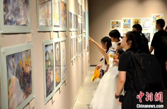 圖為家長(zhǎng)帶著孩子參觀展覽。呂明 攝