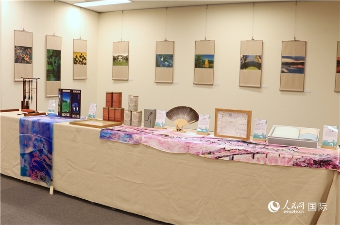 現(xiàn)場(chǎng)展出的馮學(xué)敏攝影作品與湖州市特色工藝品。（人民網(wǎng) 許可攝）
