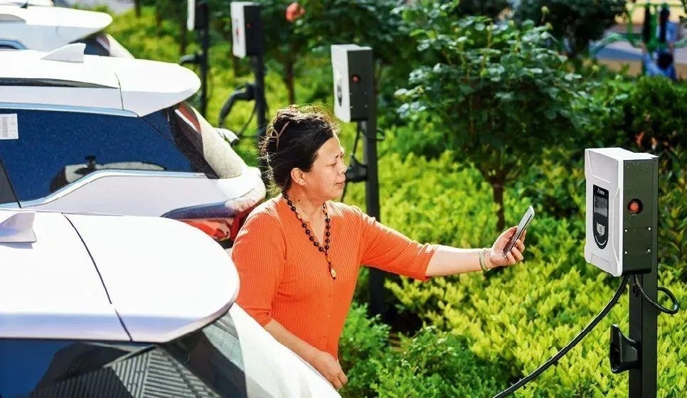 2023年5月24日，山東省膠州市新立街小區(qū)內(nèi)一位居民使用電動汽車充電樁掃碼充電。該小區(qū)加裝各類智慧設備，打造“智慧社區(qū)”，為居民生活帶來便利。