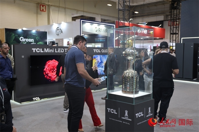 參觀者在TCL展臺前觀看南美解放者杯獎杯，據(jù)介紹，TCL是南美解放者杯（2023—2026賽季）全球官方合作伙伴。（人民網(wǎng)記者 時元皓攝）