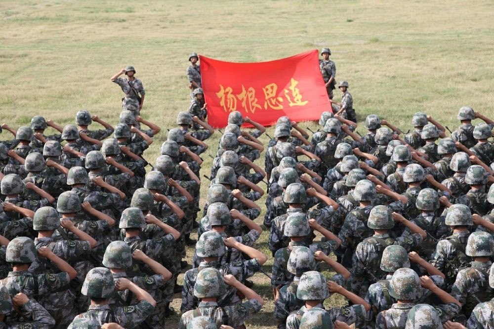 ↑“楊根思連”官兵執(zhí)行任務(wù)前向連旗宣誓（資料照片）。新華社發(fā)
