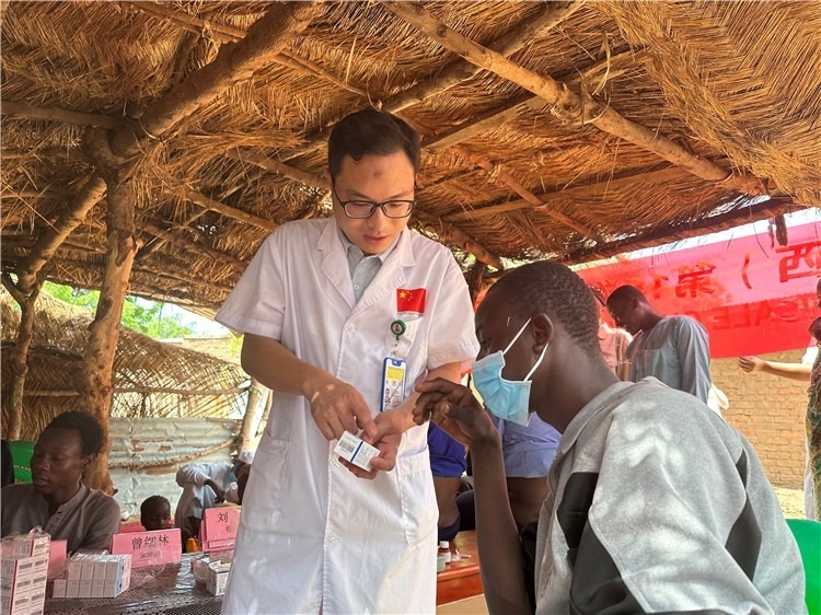 圖為南昌大學第一附屬醫(yī)院病理科主治醫(yī)師張振東為村民解說藥品使用方法。中國駐乍得醫(yī)療隊供圖