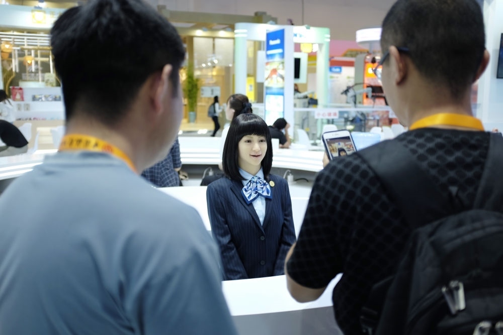 9月1日，媒體記者在國家會(huì)議中心與服務(wù)機(jī)器人互動(dòng)。新華社記者 劉夢(mèng)琪 攝