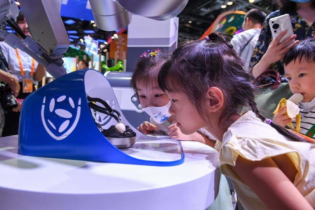 9月3日，幾名小朋友在國(guó)家會(huì)議中心觀看單孔腔鏡手術(shù)機(jī)器人展示。新華社記者 鞠煥宗 攝