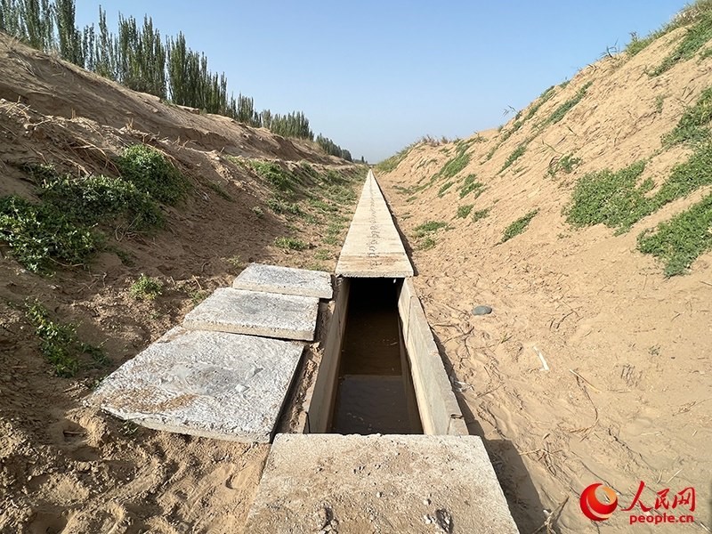 打開蓋板，可見水在寬一米、深一米的渠道內暢通流過。人民網記者 常雪梅攝