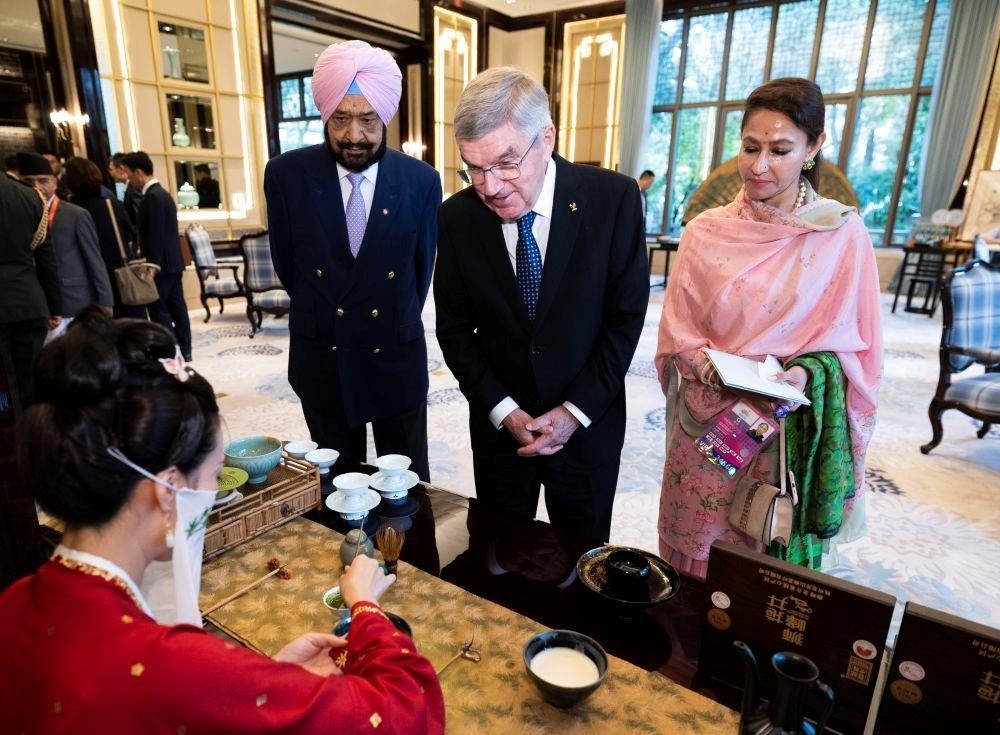 △歡迎宴會前，亞奧理事會代理主席辛格和夫人維尼塔、國際奧委會主席巴赫欣賞非遺展示。