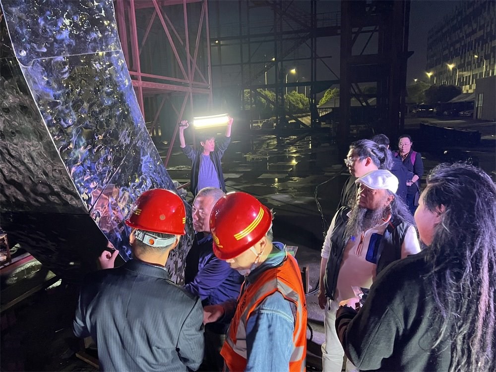 林崗（右二）和團隊查看主火炬制作進度。受訪者供圖