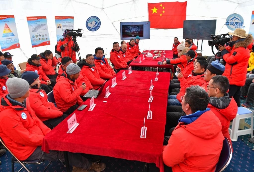 海拔4950米的卓奧友峰科考大本營，科考隊員趙華標（手拿麥克風看電腦者）在宣讀剛剛接收到的頂峰氣象觀測數(shù)據(jù)，這標志著峰頂自動氣象站架設(shè)成功，成功傳回觀測數(shù)據(jù)（10月1日攝）。新華社記者晉美多吉 攝