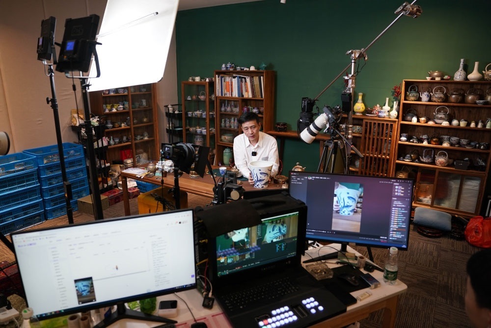 ↑在景德鎮(zhèn)，工作人員通過(guò)網(wǎng)絡(luò)直播推介陶瓷產(chǎn)品（2023年2月22日攝）。