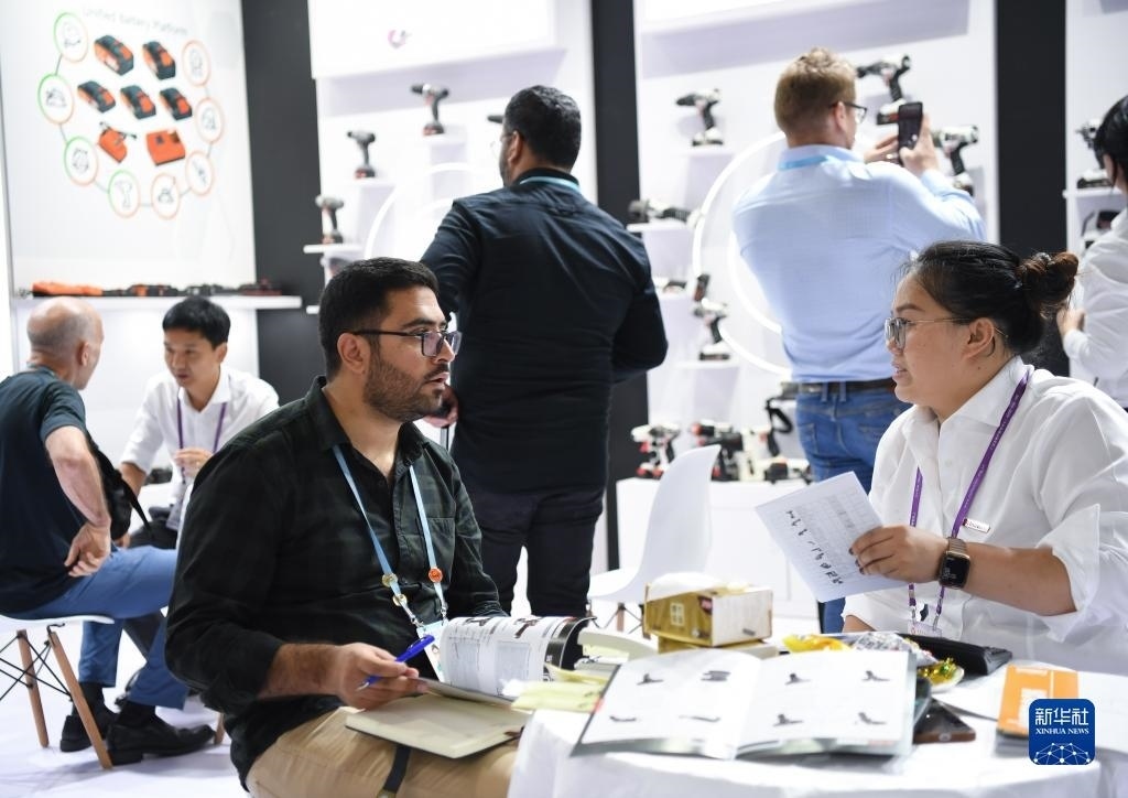 10月15日，在一家電動(dòng)工具展臺(tái)，外國(guó)采購(gòu)商在洽談業(yè)務(wù)。新華社記者 鄧華 攝