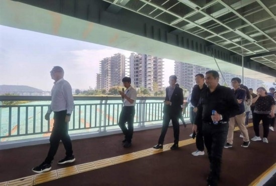 10月24日，2023“一帶一路”媒體合作論壇聯(lián)合采訪團(tuán)團(tuán)員走在清水塘大橋景觀通道上。本報(bào)記者 常雯宜攝