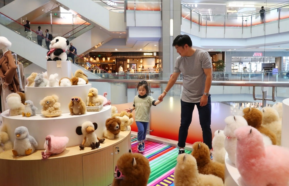 2023年11月2日，顧客在溫暖駝品牌專柜內(nèi)選購(gòu)。連續(xù)六年參加進(jìn)博會(huì)的秘魯羊駝制品品牌溫暖駝在上海市中心商場(chǎng)開設(shè)了專柜。新華社記者 方喆 攝