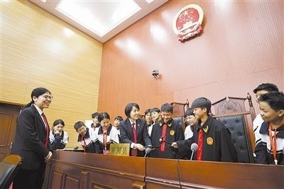圖③：同學們穿法袍、敲法槌，爭做“小法官”。