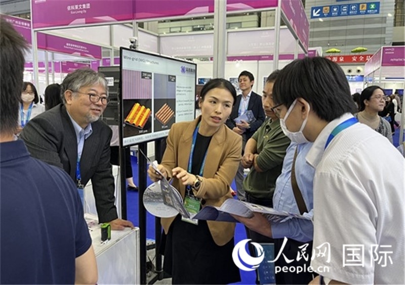 工作人員向參觀者介紹超級噴墨技術(shù)。（人民網(wǎng)記者 陳思攝）