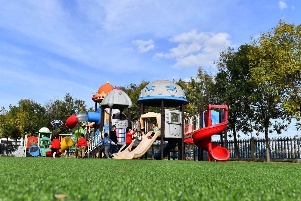 在山東省東營市墾利區(qū)楊廟社區(qū)幼兒園，孩子們在老師的帶領(lǐng)下進(jìn)行戶外活動（2021年10月19日攝）。新華社記者 郭緒雷 攝