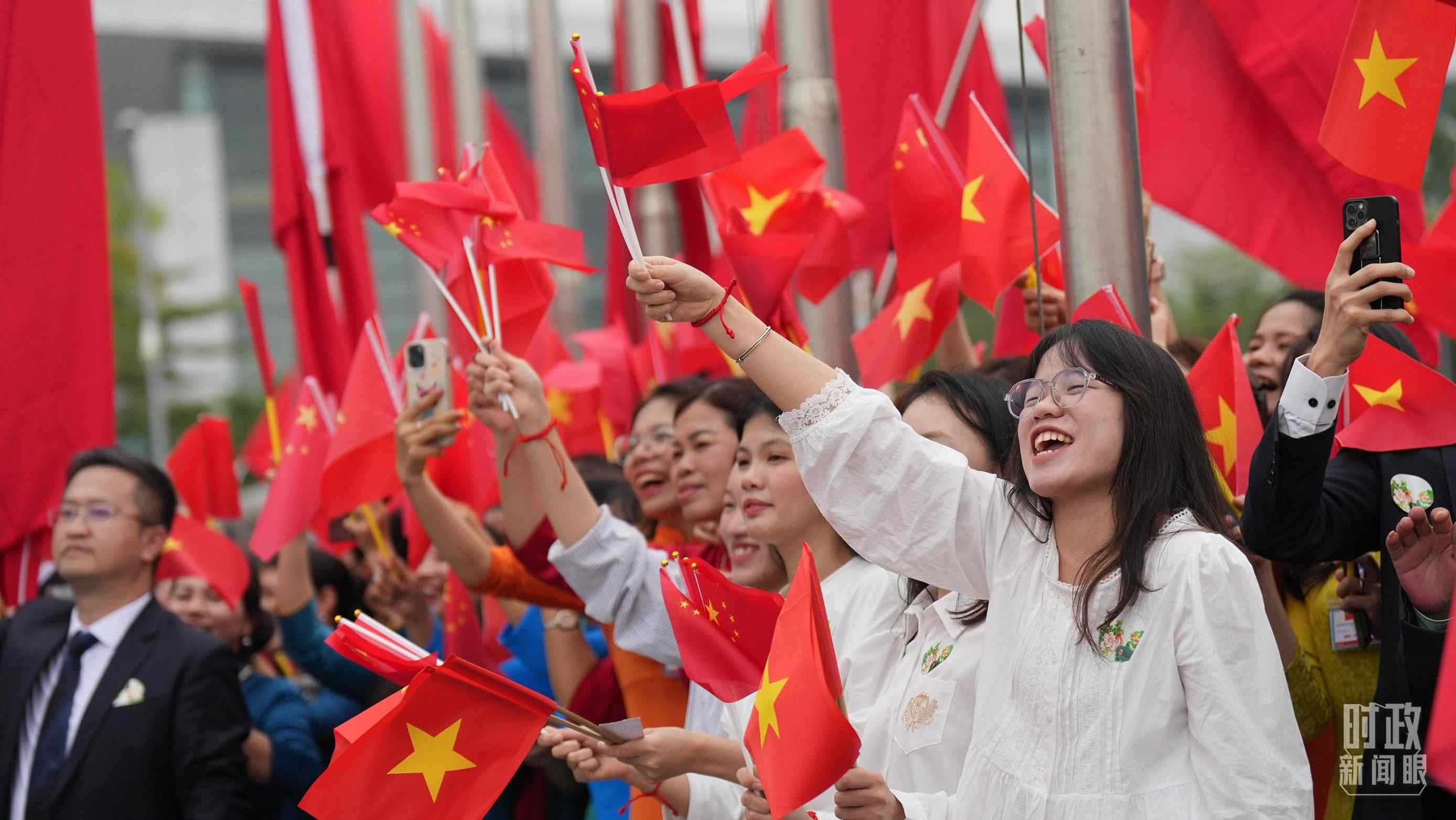 △人們揮舞兩國旗幟歡迎習(xí)近平訪越。（總臺國廣記者李晉拍攝）