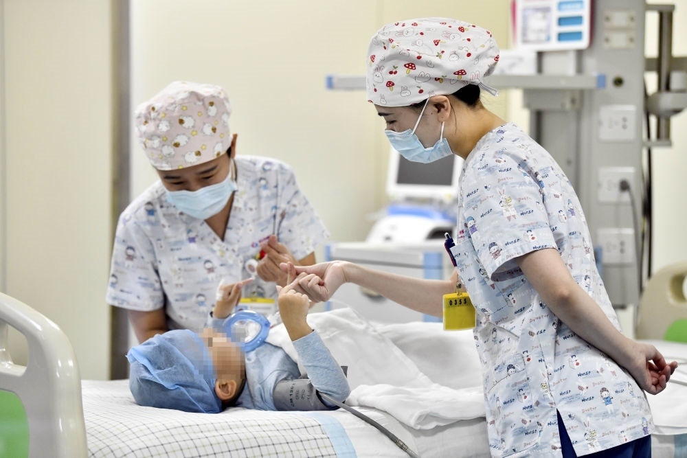 在山東省棗莊市婦幼保健院兒童ICU病房，醫(yī)護(hù)人員為完成靶向治療藥物諾西那生鈉的4歲脊髓性肌萎縮癥患兒加油鼓勁（2022年1月1日攝）。諾西那生鈉注射液是我國(guó)首個(gè)獲批治療脊髓性肌萎縮癥的進(jìn)口藥物，2019年進(jìn)入中國(guó)市場(chǎng)時(shí)，每針價(jià)格近70萬(wàn)元。在2021年國(guó)家醫(yī)保目錄藥品談判中，以3.3萬(wàn)元每針的價(jià)格進(jìn)入新版醫(yī)保藥品目錄。新華社記者 郭緒雷 攝