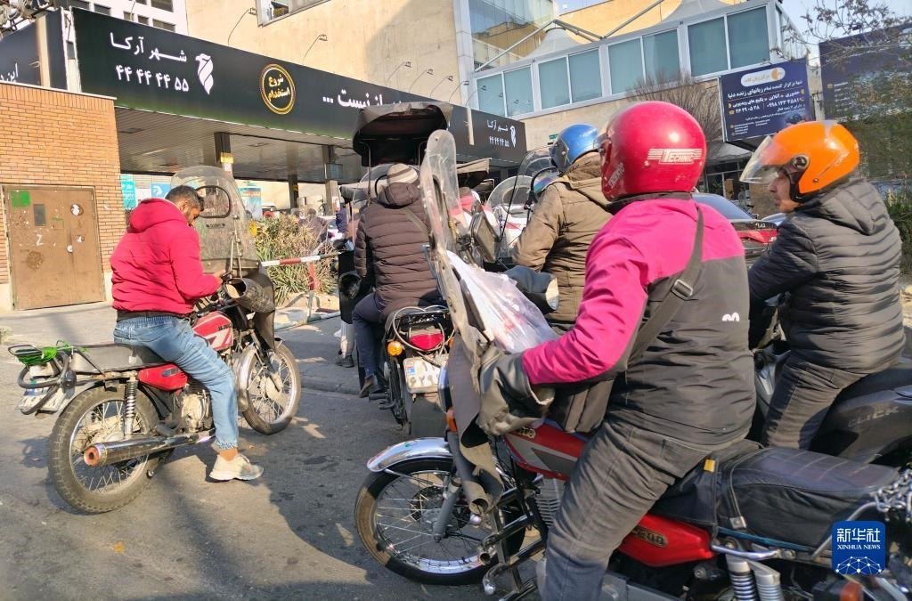 12月18日，摩托車在伊朗首都德黑蘭的一家加油站外等待加油。新華社記者 沙達(dá)提 攝