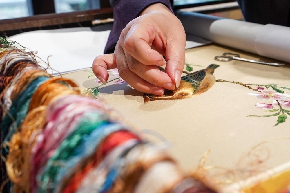 △2023年7月6日，盧建英在江蘇蘇州平江路的工作室內(nèi)刺繡。