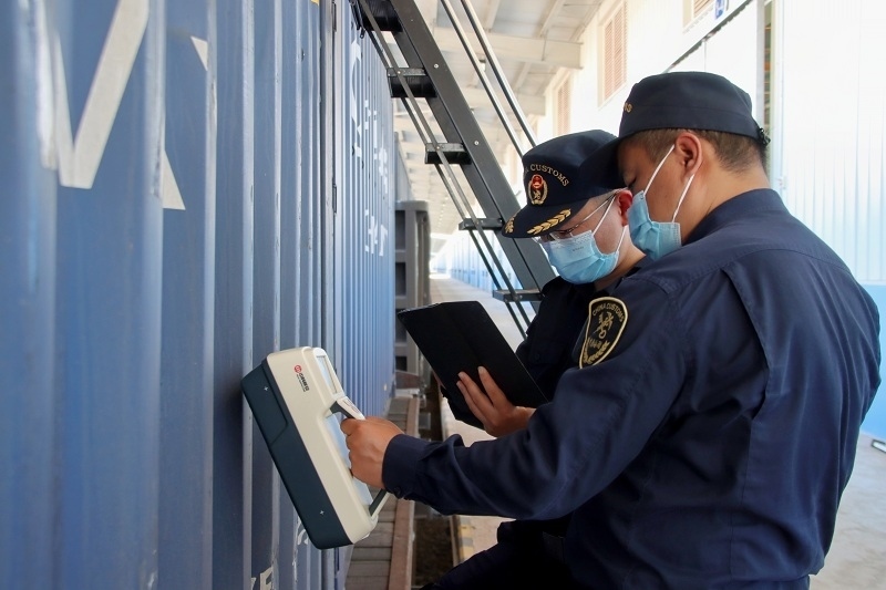 海關(guān)關(guān)員使用手持式輻射探測儀對中老鐵路入境貨物進(jìn)行檢測。張釋巍攝