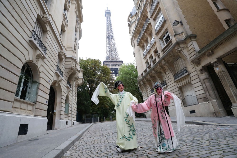 2023年9月13日，江蘇省演藝集團(tuán)昆劇院院長(zhǎng)施夏明（左）和江蘇省演藝集團(tuán)昆劇院國(guó)家一級(jí)演員孔愛(ài)萍在法國(guó)巴黎埃菲爾鐵塔附近參加昆曲快閃。新華社記者 高靜 攝