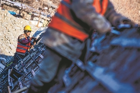 1月3日，房山區(qū)，工人正在雙泉河修筑堤壩。