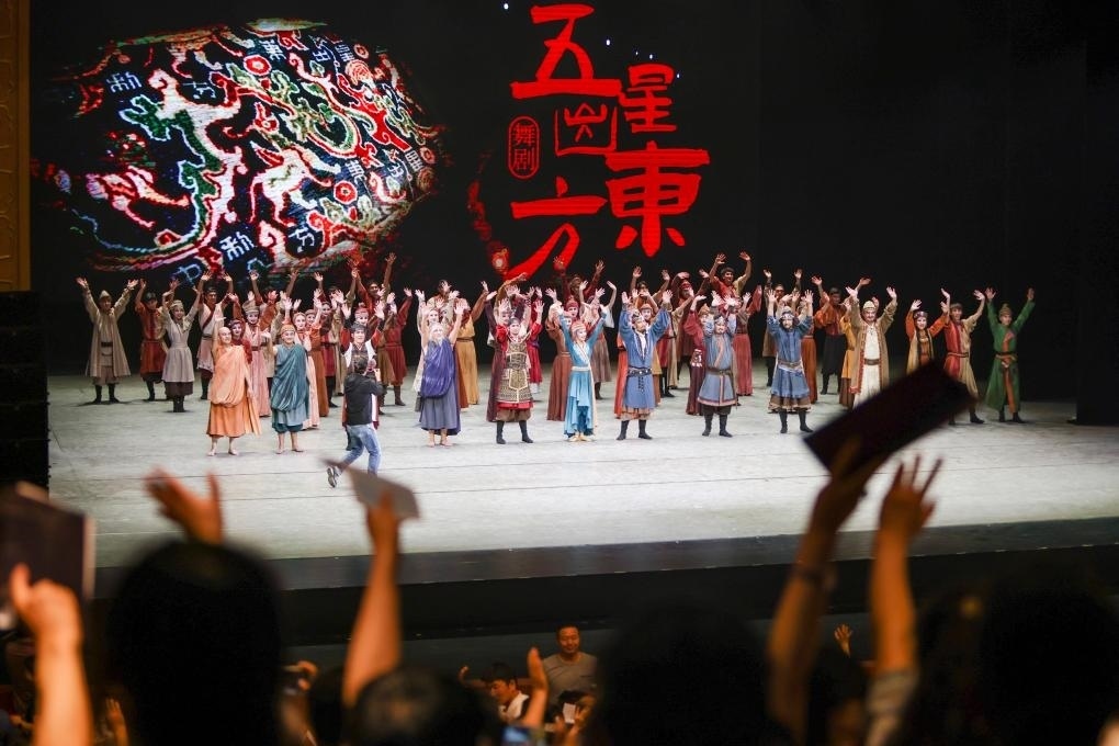 2023年7月31日，新疆和田地區(qū)新玉歌舞團在烏魯木齊京劇院演出舞劇《五星出東方》后和觀眾互相揮手致意。這場演出是第六屆中國新疆國際民族舞蹈節(jié)的參演劇目之一，曾榮獲國家“文華獎”等。新華社記者 郝昭 攝