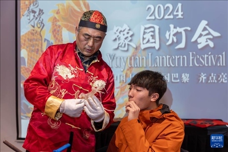 1月28日，在上海豫園舉行的民俗活動上，美國馬斯卡廷中學學生在非遺傳承人的指導下吹糖偶。 新華社記者 王翔 攝