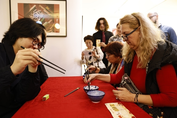 羅馬尼亞觀眾體驗用筷子夾花生。中國文化中心供圖