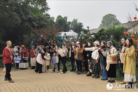 葉科（左一）給前來參與活動(dòng)的“柑爸柑媽”介紹生態(tài)種植果。人民網(wǎng)記者朱虹攝