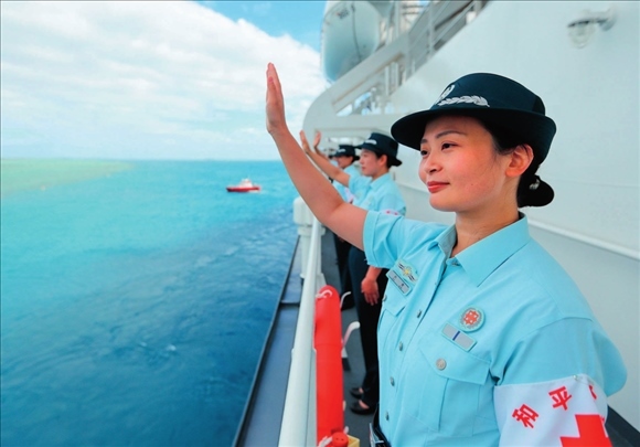 中國(guó)海軍“和平方舟”號(hào)醫(yī)院船結(jié)束訪問(wèn)湯加時(shí)，任務(wù)官兵中的文職人員向歡送人群揮手告別（2023年8月4日攝）。徐巍攝/本刊