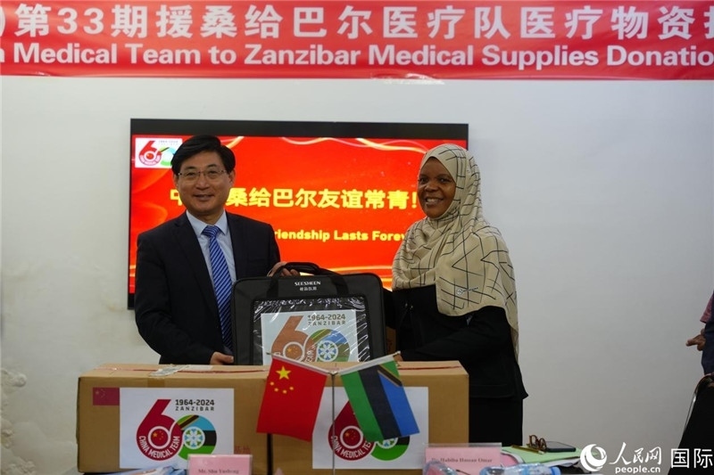 江蘇省蘇北人民醫(yī)院黨委書記束余聲捐贈(zèng)物資與桑衛(wèi)生部首席秘書哈比巴。中國(guó)援桑醫(yī)療隊(duì)供圖