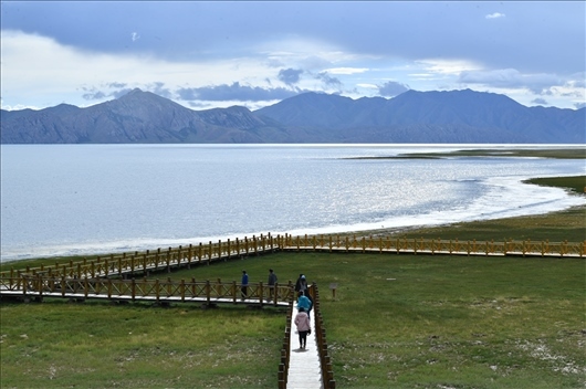 △ 游客行走在青?，敹嗫h冬格措納湖畔的木棧道上。
