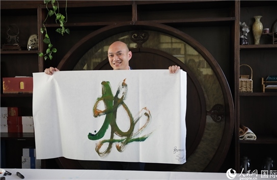 老撾駐華大使館三秘明君參加《五百筆·瀾湄合作》集體藝術(shù)創(chuàng)作。人民網(wǎng)王婧攝。