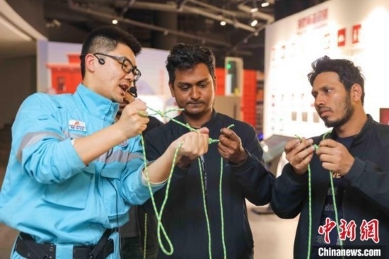 5月9日，工作人員指導(dǎo)留學(xué)生學(xué)習(xí)打繩結(jié)。張鷹 攝