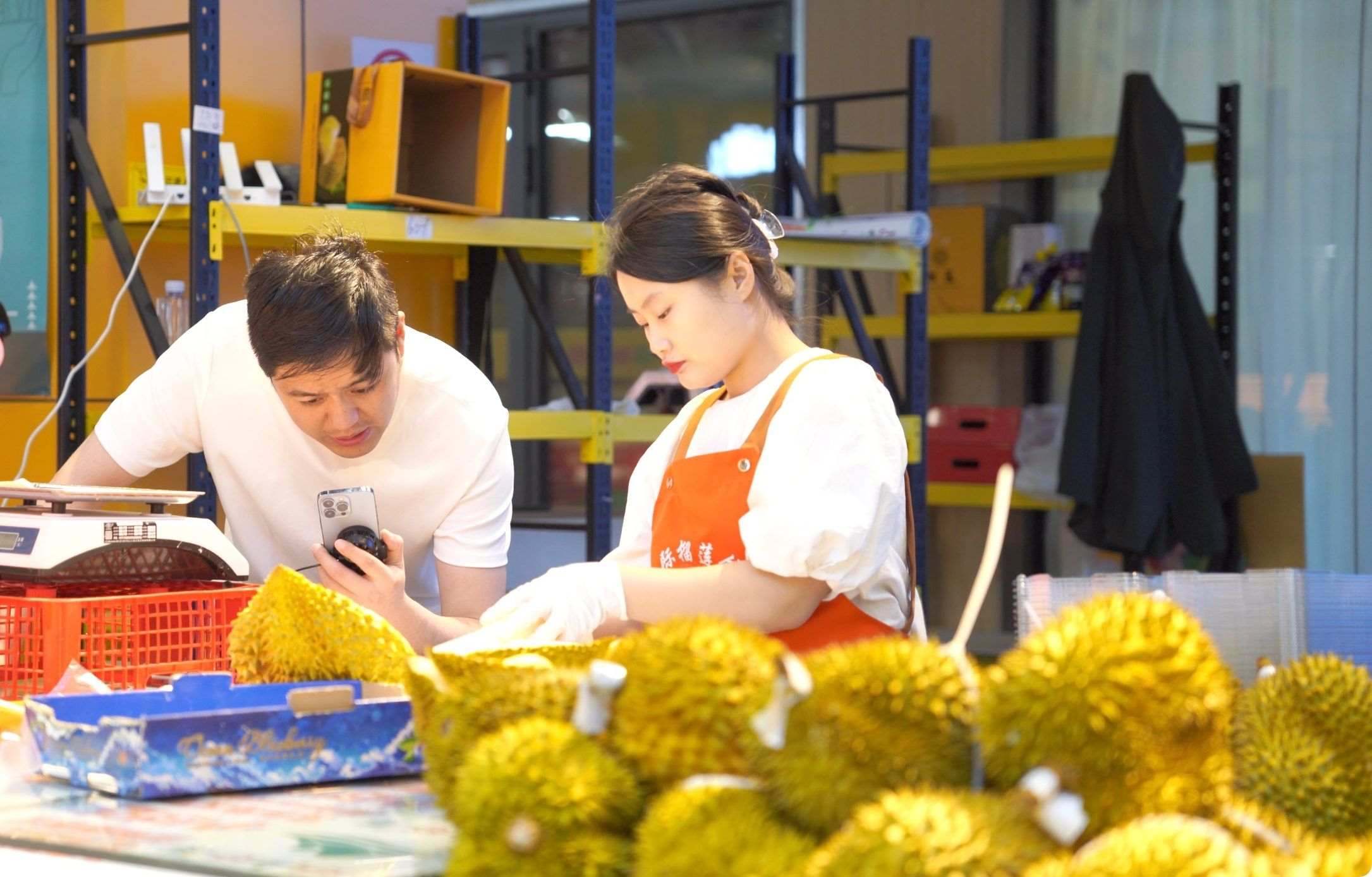 榴蓮商家正在通過(guò)手機(jī)直播銷(xiāo)售榴蓮。人民網(wǎng)記者申佳平 攝