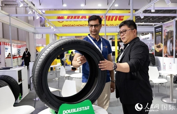 工作人員向客戶展示雙星電動汽車輪胎。和傳統(tǒng)汽車輪胎相比，電動汽車輪胎具有更高承載能力、更加靜音舒適、更好極速抓地、更低滾動阻力等特點。人民網(wǎng)記者 管克江攝