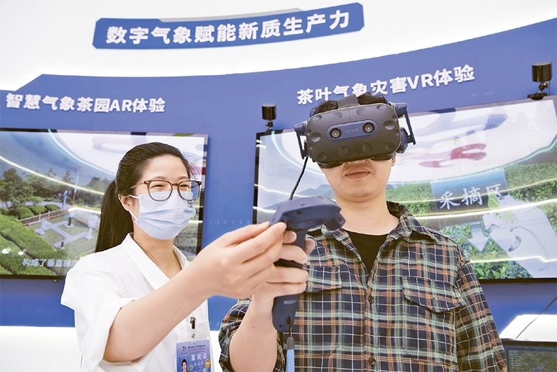 2024年5月23日，第七屆數(shù)字中國建設(shè)峰會(huì)現(xiàn)場(chǎng)體驗(yàn)區(qū)在福州海峽國際會(huì)展中心向?qū)I(yè)觀眾開放。本次現(xiàn)場(chǎng)體驗(yàn)區(qū)圍繞本屆峰會(huì)主題“釋放數(shù)據(jù)要素價(jià)值，發(fā)展新質(zhì)生產(chǎn)力”，設(shè)置“數(shù)字惠民”、“數(shù)字能力”、“數(shù)字基礎(chǔ)”、“數(shù)字生態(tài)”、“數(shù)字賦能”五大板塊。圖為一名觀眾（右）在數(shù)字氣象賦能新質(zhì)生產(chǎn)力展臺(tái)上進(jìn)行體驗(yàn)。 新華社記者 魏培全/攝