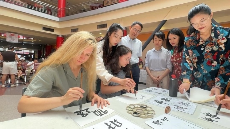 羅馬尼亞友人在活動(dòng)現(xiàn)場(chǎng)學(xué)寫(xiě)漢字。中國(guó)駐羅馬尼亞大使館領(lǐng)僑處供圖