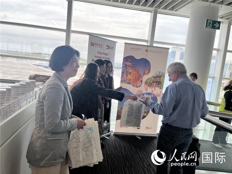 圖為工作人員向乘客發(fā)放復(fù)航首班禮物。 牛瑞飛攝